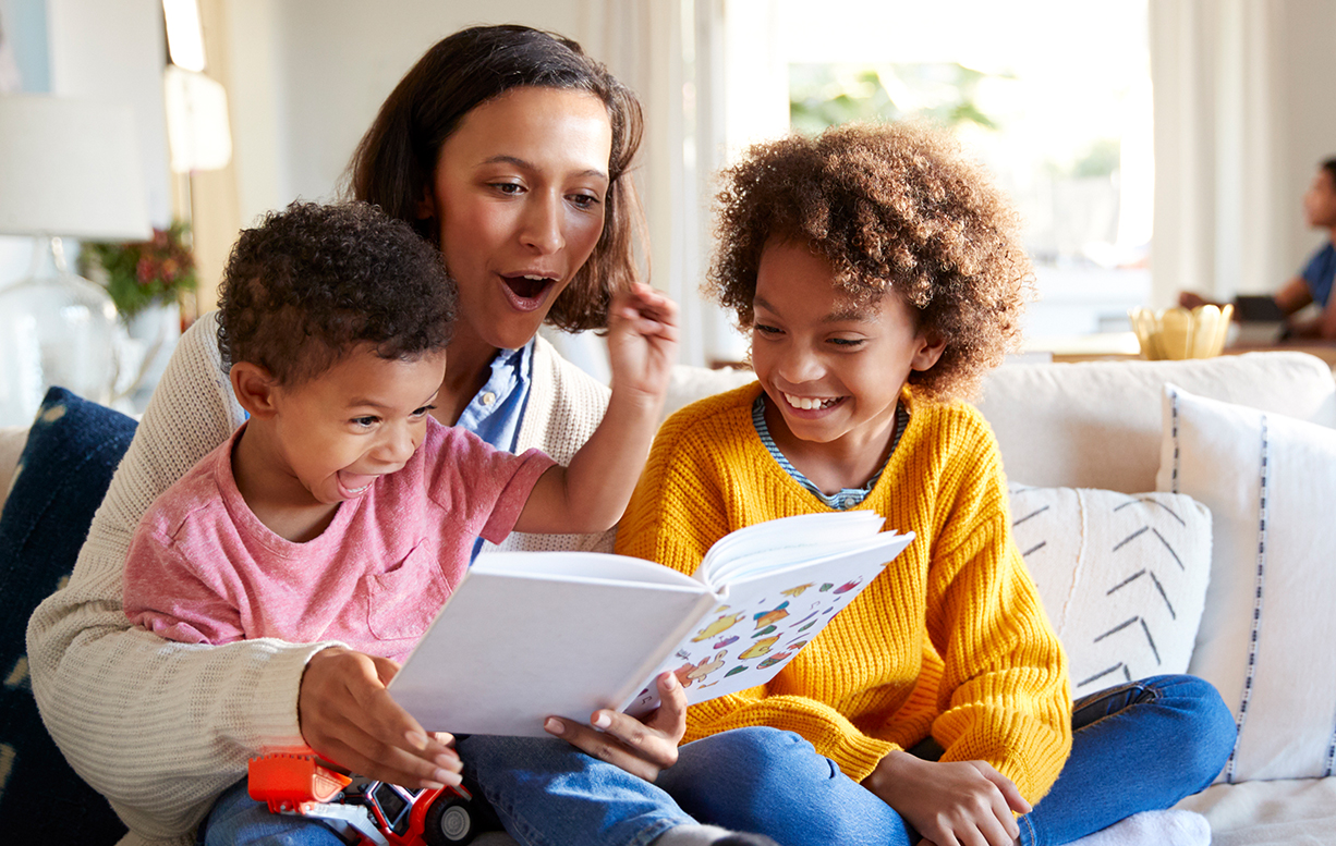 woman reading a book to children